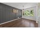 Dining room featuring gray accent wall, modern lighting, hardwood floors, and large windows at 2317 Bertie Dr, Raleigh, NC 27610