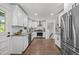 Updated kitchen with stainless steel appliances, white cabinetry, granite countertops, and hardwood floors at 2317 Bertie Dr, Raleigh, NC 27610