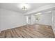 Bright living room featuring wood-look flooring, paneled walls, and modern light fixture at 2317 Bertie Dr, Raleigh, NC 27610