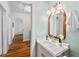 Powder room boasts vintage lighting and fixtures with wood-look flooring at 2504 State St, Durham, NC 27704