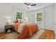 Inviting bedroom with natural light, cozy bedding, stylish mirror, and ceiling fan at 2504 State St, Durham, NC 27704