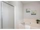 Bright bathroom showcasing a soaking tub with a shower and decorative beach-themed artwork at 2644 Bloomsberry Ridge Dr, Fuquay Varina, NC 27526