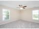 Spacious bedroom showcasing neutral carpet, ceiling fan, and two large windows at 2644 Bloomsberry Ridge Dr, Fuquay Varina, NC 27526
