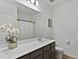 Bathroom with a large mirror, sleek countertops, stylish cabinets, and modern fixtures at 265 Purple Aster St, Youngsville, NC 27596
