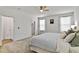 Light, airy bedroom featuring carpet, a ceiling fan, a comfortable bed and a walk-in closet at 265 Purple Aster St, Youngsville, NC 27596