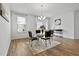 Dining area with modern table and chairs set on an area rug, under a chandelier and natural light at 265 Purple Aster St, Youngsville, NC 27596