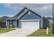 Charming single-story home with blue siding, two-car garage, and a well-maintained green lawn at 265 Purple Aster St, Youngsville, NC 27596