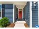 Close-up of a red front door with 'hello' sign, wreath, and ADT security sign at 265 Purple Aster St, Youngsville, NC 27596