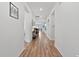 Bright hallway with hardwood floors and neutral walls showcasing a view into other living spaces at 265 Purple Aster St, Youngsville, NC 27596