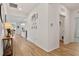 Bright hallway with wood floors, white walls and gallery wall leading to open floorplan at 265 Purple Aster St, Youngsville, NC 27596