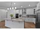 Spacious kitchen features white cabinets, granite countertops, stainless steel appliances, and modern lighting at 265 Purple Aster St, Youngsville, NC 27596