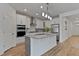Bright kitchen with white cabinets, granite countertops, stainless steel appliances, and kitchen island at 265 Purple Aster St, Youngsville, NC 27596