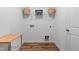 Well-lit laundry room with modern shelving, wood-look flooring, and ample space for appliances at 265 Purple Aster St, Youngsville, NC 27596