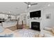 Bright living room with fireplace, wood floors, open floorplan, and a view to the kitchen at 265 Purple Aster St, Youngsville, NC 27596