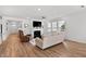 Bright living room with fireplace, wood floors, neutral furniture and large windows at 265 Purple Aster St, Youngsville, NC 27596