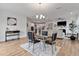 Open-concept living space with a dining area, modern chandelier, and view of the living room and kitchen at 265 Purple Aster St, Youngsville, NC 27596