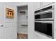 Walk-in pantry with wire shelving located next to built in oven and microwave at 265 Purple Aster St, Youngsville, NC 27596