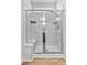 Modern walk-in shower with marble-style tiling, a glass door, and built-in shower seating at 265 Purple Aster St, Youngsville, NC 27596
