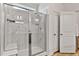 Modern walk-in shower featuring marble-style tile, a glass door, and built-in shower seating at 265 Purple Aster St, Youngsville, NC 27596
