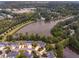 Stunning aerial view of a residential community surrounded by a lake and lush greenery at 3 Waconda Ct, Durham, NC 27713