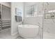Bright bathroom featuring a soaking tub, glass block window, and marble tile in the shower at 3 Waconda Ct, Durham, NC 27713