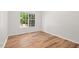 Vacant bedroom with bright lighting, wood floors, and a large window, ready for personalization at 3 Waconda Ct, Durham, NC 27713