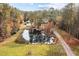 Aerial view of private pond, surrounded by mature trees, and charming home at 3564 Lower Moncure Rd, Sanford, NC 27330