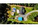 Aerial view of the property showcasing the pool, multiple structures, and surrounding wooded landscape at 3564 Lower Moncure Rd, Sanford, NC 27330