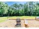 Landscaped backyard featuring a fire pit, bench seating, and mature trees for privacy and relaxation at 3564 Lower Moncure Rd, Sanford, NC 27330