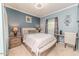 Cozy bedroom with blue walls, a bed with decorative pillows, and a small desk at 3564 Lower Moncure Rd, Sanford, NC 27330