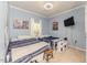 Shared bedroom with two beds, light blue walls, and a large TV at 3564 Lower Moncure Rd, Sanford, NC 27330