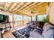Relaxing screened-in porch with wood ceiling, comfortable seating, ceiling fan, and nature views at 3564 Lower Moncure Rd, Sanford, NC 27330