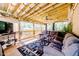 Relaxing screened-in porch with wood ceiling, comfortable seating, ceiling fan, and nature views at 3564 Lower Moncure Rd, Sanford, NC 27330