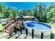 Enjoy the sunny day with this backyard pool surrounded by mature trees and deck at 3564 Lower Moncure Rd, Sanford, NC 27330