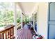 Inviting porch with decorative columns, cozy seating, and views of surrounding greenery at 3564 Lower Moncure Rd, Sanford, NC 27330