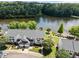 An aerial view shows the well-maintained townhome with manicured lawns near the serene lake at 400 Nottinghill Walk, Apex, NC 27502
