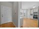 Inviting foyer leading to a modern kitchen and dining area with hardwood floors at 400 Nottinghill Walk, Apex, NC 27502