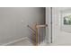 Hallway featuring neutral paint, carpet flooring, wooden banister and natural light from window at 400 Nottinghill Walk, Apex, NC 27502