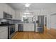 Modern kitchen with stainless steel appliances, gray backsplash, and view to living area at 400 Nottinghill Walk, Apex, NC 27502