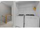 Bright upstairs laundry room featuring modern washer and dryer units with shelving at 400 Nottinghill Walk, Apex, NC 27502