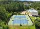 Overhead view showcasing the fenced tennis courts with visible lighting near a pool and community building at 400 Nottinghill Walk, Apex, NC 27502