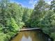 A scenic bridge in a wooded area offers residents a charming spot to enjoy nature and serene water views at 400 Nottinghill Walk, Apex, NC 27502