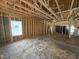 View of the unfinished interior with exposed wood beams and stud framing, showcasing the open floor plan at 4026 N Nc 581 Hwy, Kenly, NC 27542