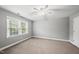 Bright bedroom featuring neutral walls, plush carpeting, and a ceiling fan for added comfort at 405 E Millbrook Rd, Raleigh, NC 27609