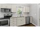 Well-lit kitchen features stainless appliances, white cabinets, a double sink, and a subway tile backsplash at 405 E Millbrook Rd, Raleigh, NC 27609