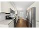 Modern kitchen showcasing stainless steel appliances, gray countertops, white cabinets, and hardwood floors at 405 E Millbrook Rd, Raleigh, NC 27609