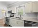 Bright kitchen features stainless appliances, gray counters, white cabinets, subway tile backsplash, and a double sink at 405 E Millbrook Rd, Raleigh, NC 27609