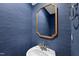 Stylish powder room with blue textured wallpaper, bronze-trimmed mirror, and classic fixtures at 405 E Millbrook Rd, Raleigh, NC 27609