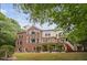 Rear exterior of the house featuring a brick facade, windows, and an outdoor deck at 409 Englewood Dr, Chapel Hill, NC 27514