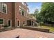 Spacious backyard featuring a brick patio, exterior doors, and lush landscaping at 409 Englewood Dr, Chapel Hill, NC 27514